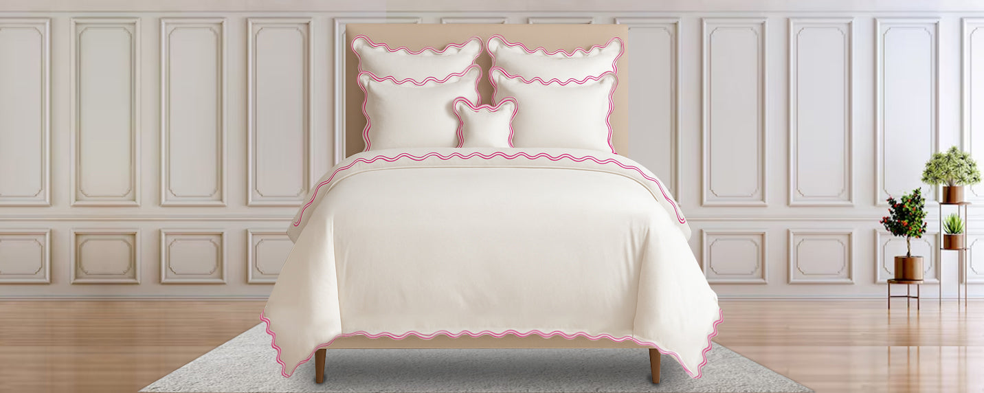Bed with white bedding and pink trim